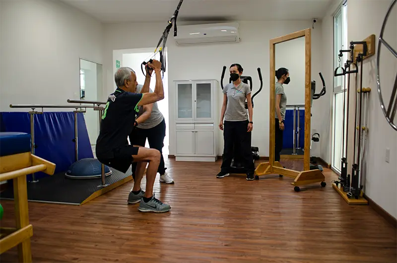 Paciente geriátrico realizando ejercicios de fuerza y control de movimiento en la clínica de terapia física y funcional norte